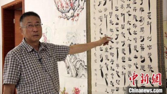 圖為朱群和他的敦煌漢簡(jiǎn)書(shū)體?！「攥?攝