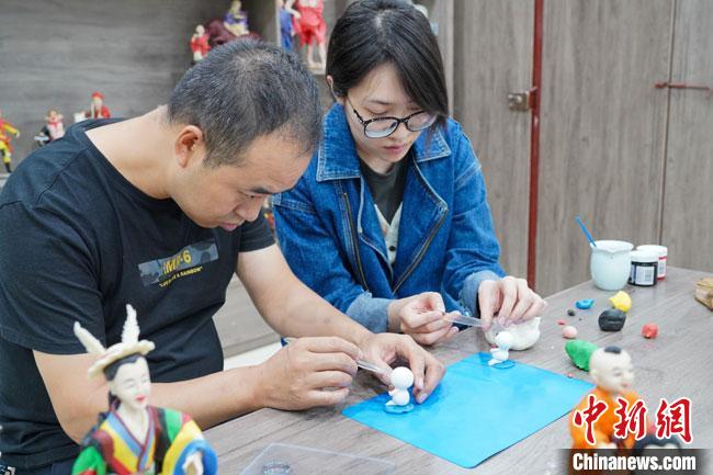 <a target='_blank'  data-cke-saved- >中新社</a>記者(右)現(xiàn)場(chǎng)體驗(yàn)面塑制作過(guò)程?！￡悹?zhēng)強(qiáng) 攝