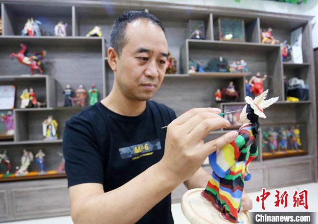 圖為安秋平正在創(chuàng)作代表隴南文縣民俗的《白馬人》作品?！「哒?攝