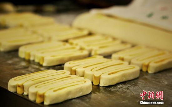 圖為面劑被涂上胡麻油，切成條狀用作月餅的花型制作。張文 攝