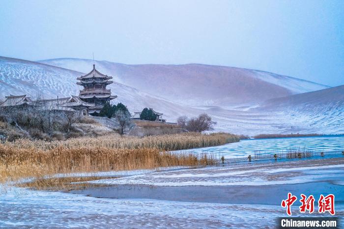 2021年11月28日，雪落鳴沙山月牙泉景區(qū)?！⊥醣筱y 攝