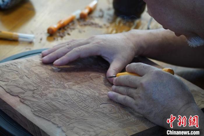 圖為徐晉林湊近木板，近距離制作雕版畫。　九美旦增 　攝