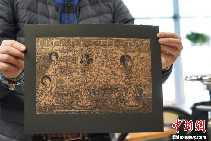 圖為手工書藝人展示敦煌雕版壁畫印刷品?！【琶赖┰?　攝