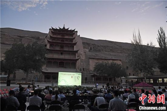 2018年8月，在敦煌莫高窟標(biāo)志性建筑“九層樓”前，《回顧平山郁夫先生的貢獻(xiàn)》座談會(huì)舉行。來自中日兩國的專家、學(xué)者共同懷念這位情系敦煌數(shù)十載的繪畫巨匠、中日友好的文化使者、世界文化遺產(chǎn)的守護(hù)者。中新社記者 楊艷敏 攝