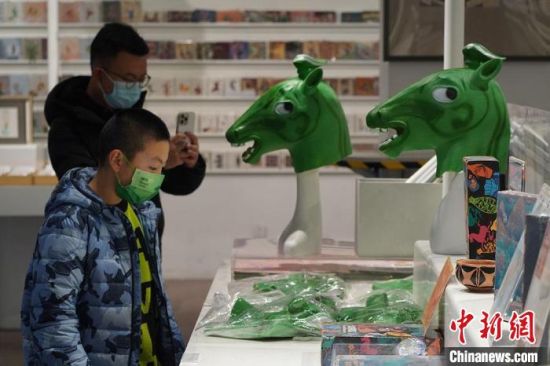 圖為“神馬來了”銅奔馬頭套吸引參觀者駐足。　九美旦增 攝