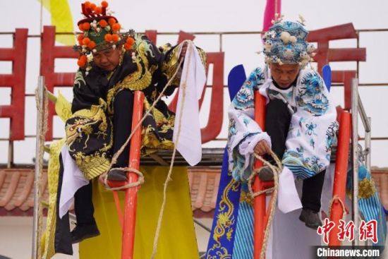 圖為“苦水高高蹺”表演者通過(guò)麻繩將腳固定在腳踏板，并在腿部纏繞六七圈?！【琶赖┰?攝