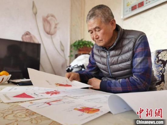 圖為陸鵬飛向記者展示多年帶隊(duì)的手寫筆記?！堟?攝