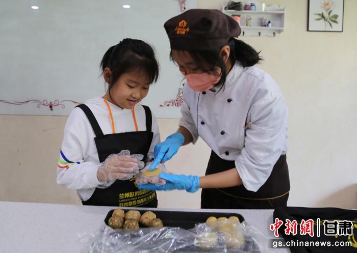 圖為在甘臺胞小朋友在工作人員指導(dǎo)下制作月餅。九美旦增 攝