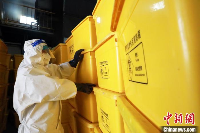 圖為工作人員搬運醫(yī)療廢物專用周轉箱。　魏建軍 攝