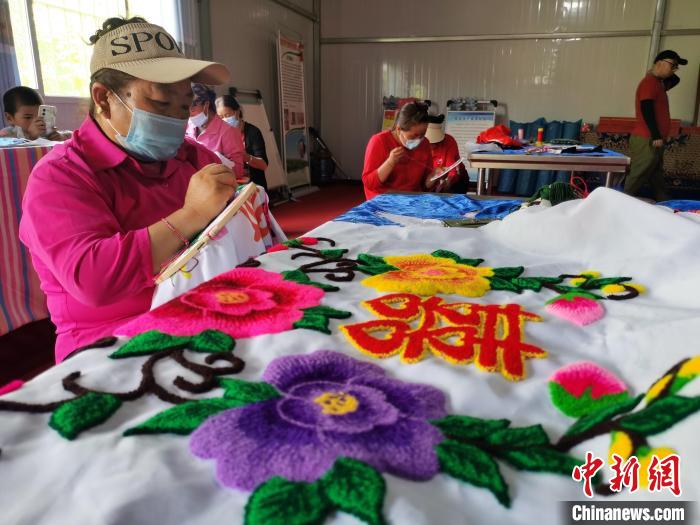 圖為婦女制作青繡?！?zhí)砀?攝