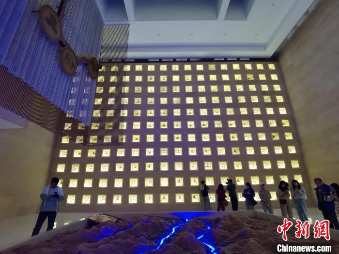 圖為河湟文化博物館序廳的左右彩陶墻放置的374件彩陶?！?zhí)砀?攝