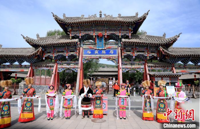 圖為身穿土族服飾的工作人員迎接訪客?！⊙Φ?攝