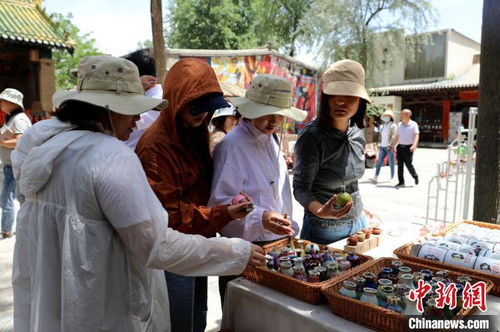 圖為民眾挑選手工藝產(chǎn)品?！⊙Φ?攝