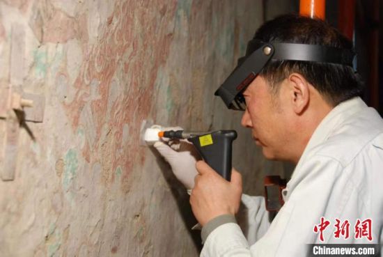 敦煌研究院研究員樊再軒進(jìn)行壁畫(huà)修復(fù)。(資料圖)張?jiān)莆?攝