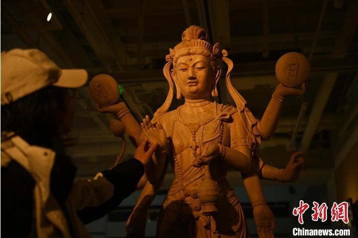 圖為季茂杰觀察自己創(chuàng)作的敦煌木雕。李亞龍 攝</p>
<p>