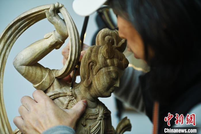 圖為季茂杰進行敦煌元素的木雕創(chuàng)作。李亞龍 攝</p>
<p>