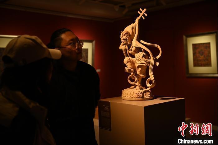 圖為季茂杰向參觀者介紹自己創(chuàng)作敦煌木雕的過程。李亞龍 攝</p>
<p>