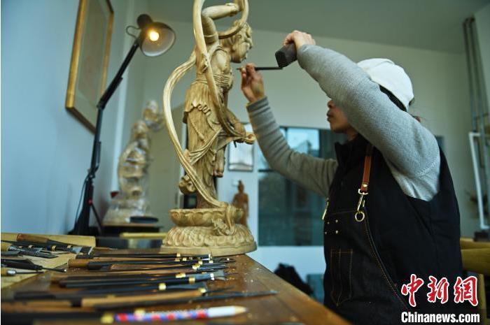 圖為季茂杰進行敦煌元素的木雕創(chuàng)作。李亞龍 攝</p>
<p>