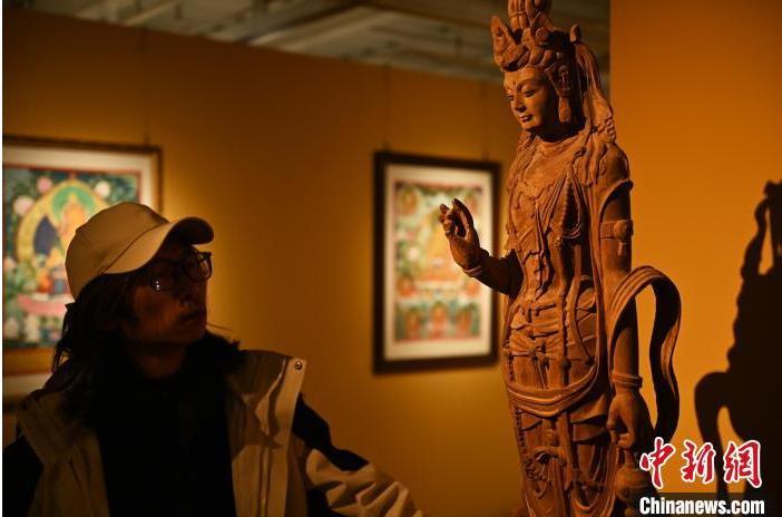 圖為季茂杰觀察自己創(chuàng)作的敦煌木雕。李亞龍 攝</p>
<p>