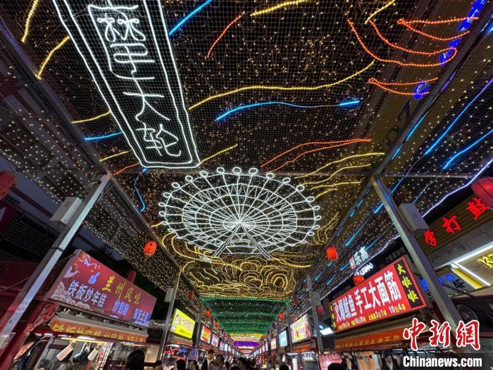 圖為明清街夜市燈光點(diǎn)亮具有武威文化元素的“摩天輪”彩燈。　戴文昌 攝</p><p>