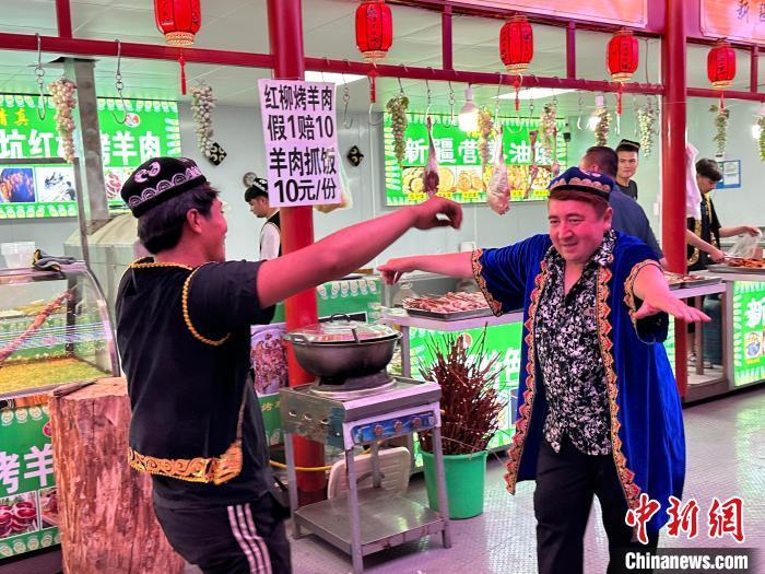 圖為餐飲經(jīng)營(yíng)者在“西涼不夜城”跳起舞蹈引客?！〈魑牟?攝</p><p>