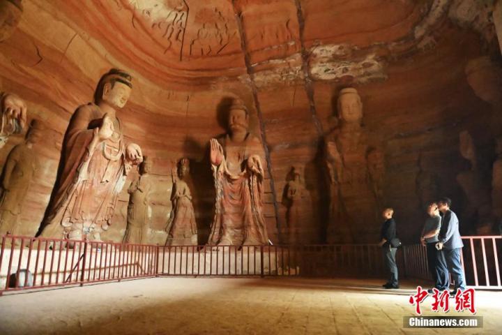 7月15日，游人參觀甘肅省平?jīng)鍪袥艽h百里石窟長廊中的南石窟寺1號窟。百里石窟長廊位于涇川縣境內，由512個石窟、5眼窟中石井組成，現(xiàn)存王母宮石窟、鳳凰山石窟、南石窟寺、丈八寺石窟、羅漢洞石窟、太山寺石窟等規(guī)模較大的石窟群，還有數(shù)量眾多的小石窟群。南石窟寺開鑿于北魏永平三年，其中1號窟屬于大型七佛窟，七佛高達6米。中新社記者 李亞龍 攝