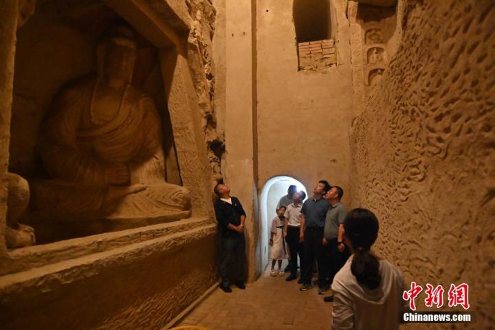 7月15日，游人參觀甘肅省平?jīng)鍪袥艽h百里石窟長廊中的王母宮石窟。百里石窟長廊位于涇川縣境內，由512個石窟、5眼窟中石井組成，現(xiàn)存王母宮石窟、鳳凰山石窟、南石窟寺、丈八寺石窟、羅漢洞石窟、太山寺石窟等規(guī)模較大的石窟群，還有數(shù)量眾多的小石窟群。王母宮石窟又名千佛洞，該窟設計宏大，造像生動，窟內擁有造像數(shù)百尊，是較為珍貴的佛教文化歷史遺存。中新社記者 李亞龍 攝</p>
<p>