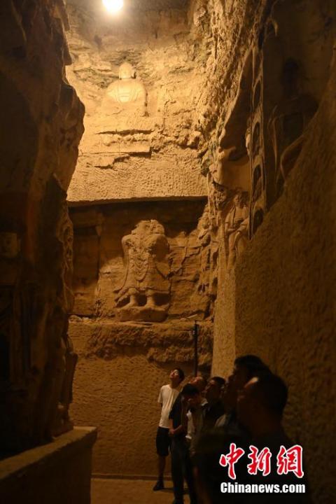 7月15日，游人參觀甘肅省平?jīng)鍪袥艽h百里石窟長廊中的王母宮石窟。百里石窟長廊位于涇川縣境內，由512個石窟、5眼窟中石井組成，現(xiàn)存王母宮石窟、鳳凰山石窟、南石窟寺、丈八寺石窟、羅漢洞石窟、太山寺石窟等規(guī)模較大的石窟群，還有數(shù)量眾多的小石窟群。王母宮石窟又名千佛洞，該窟設計宏大，造像生動，窟內擁有造像數(shù)百尊，是較為珍貴的佛教文化遺存。中新社記者 李亞龍 攝</p>
<p>