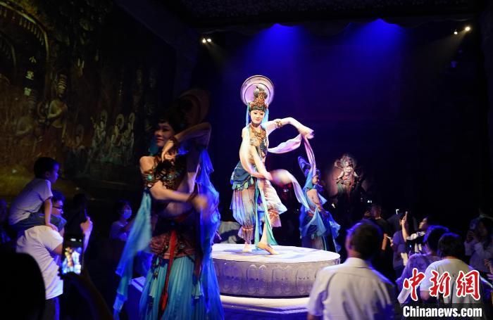 《樂動(dòng)敦煌》是全球首部洞窟式沉浸體驗(yàn)劇，利用真人與數(shù)字影像虛實(shí)交換實(shí)現(xiàn)沉浸式體驗(yàn)。圖為2023年8月28日晚，《樂動(dòng)敦煌》演出。(資料圖)中新社記者 毛建軍 攝