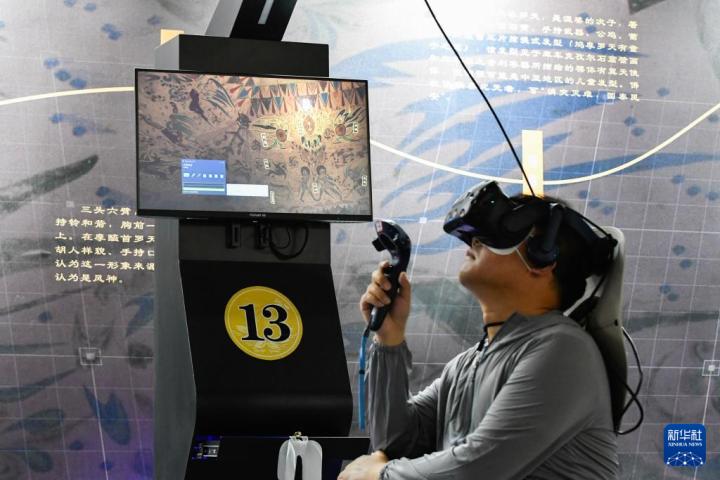 7月22日，游客借助VR設(shè)備沉浸式游覽莫高窟第285窟虛擬場景。新華社記者 郎兵兵 攝